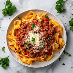 rich bolognese fresh papperdelle with cheese and parsley dark image on concrete bench white marble